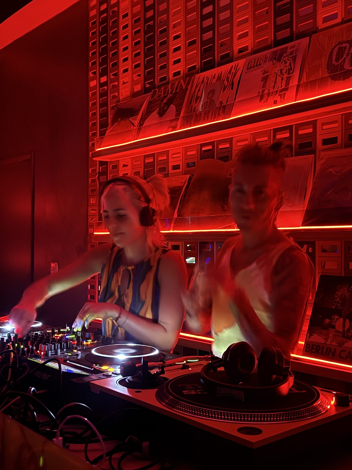 Cabina de DJ con vinilos y luz roja en OYE, listening bar en Mendoza