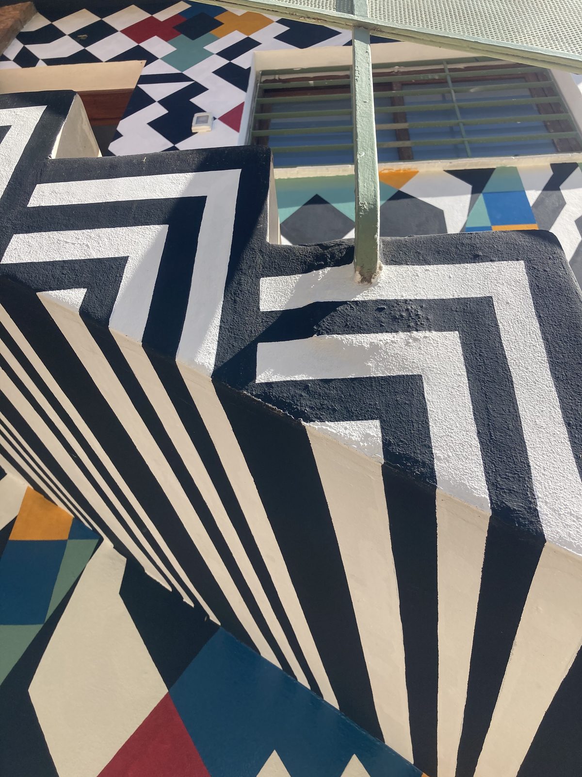 Pared con mural geométrico op-art en OYE Mendoza